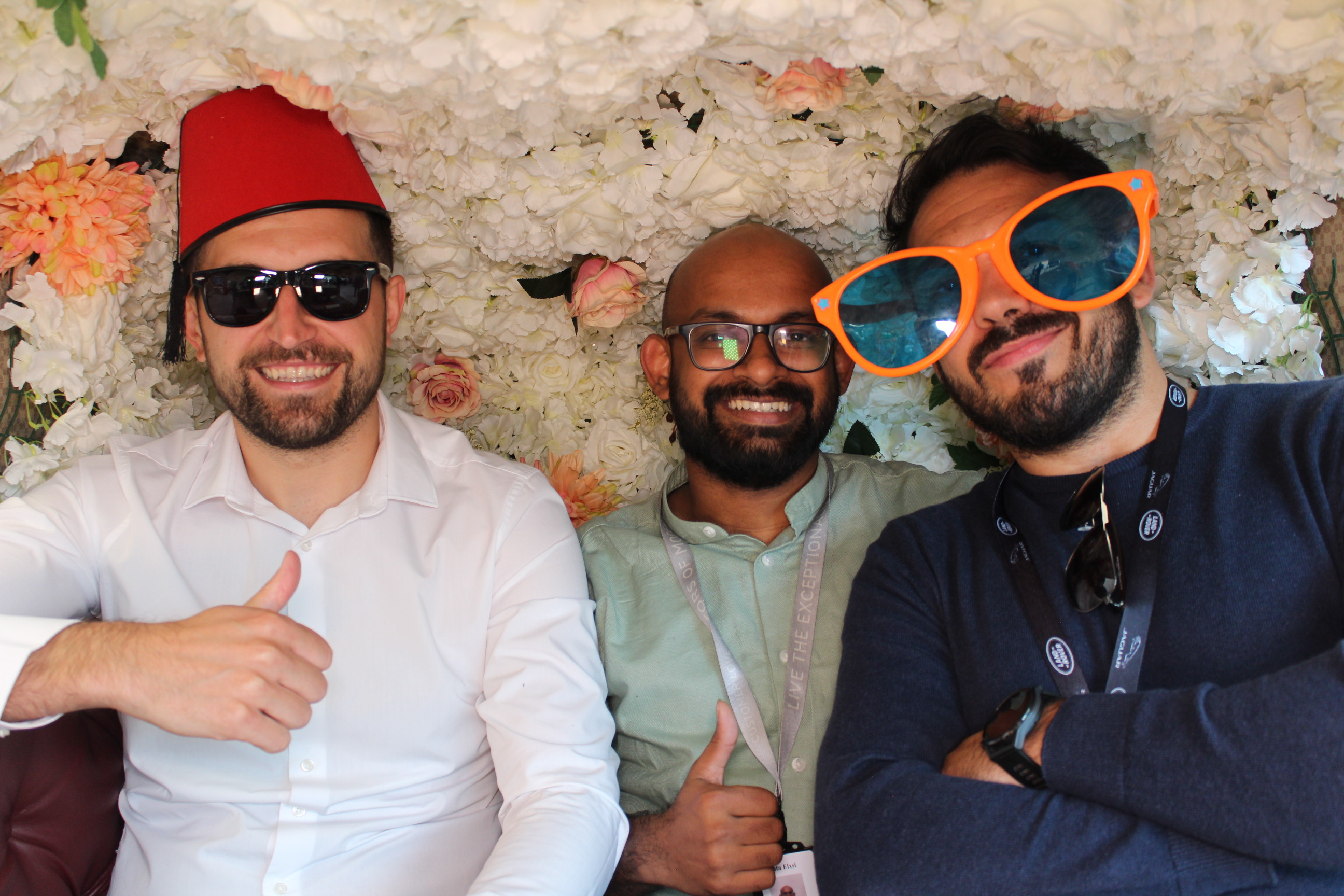 Guest wearing novelty glasses and hats in a wedding photobooth
